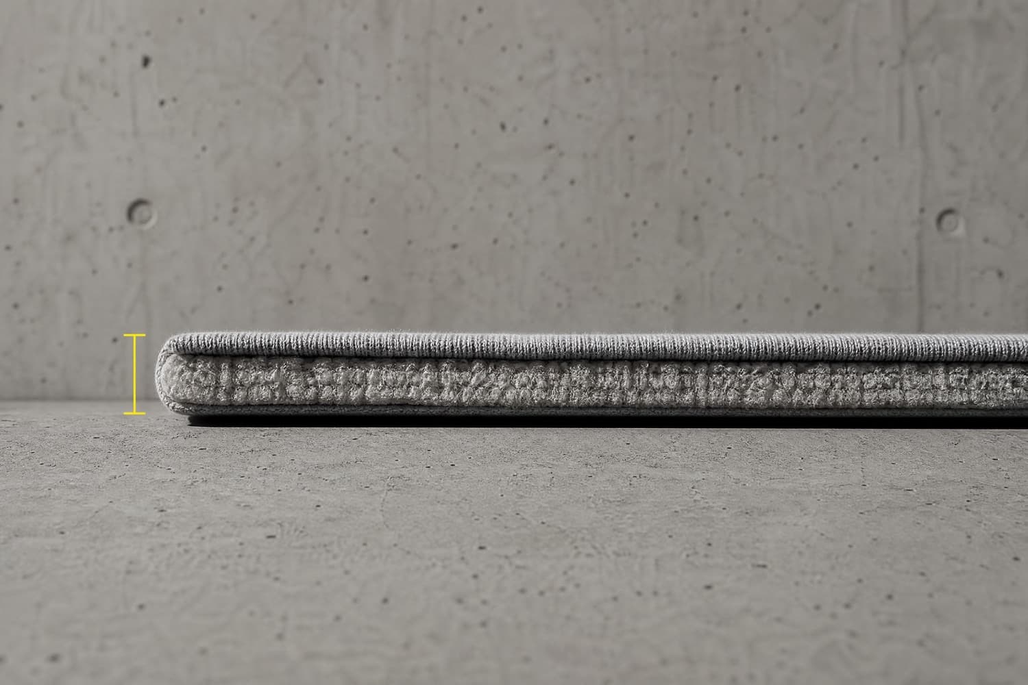 The cut edge of a heavy cotton knit photographed side on against a measurement mark